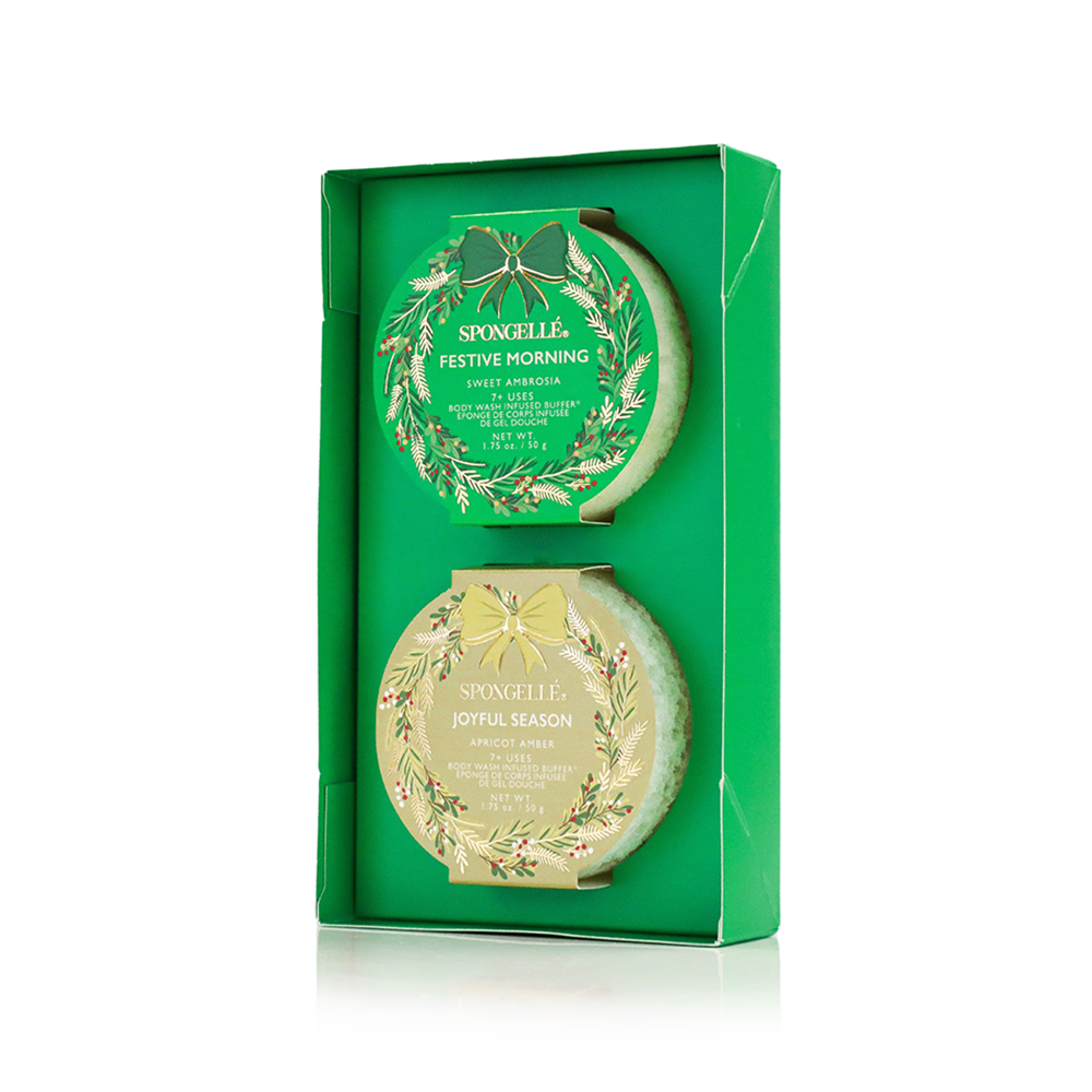 Two green and gold body buffers in decorative boxes on a white background