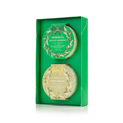 Two green and gold body buffers in decorative boxes on a white background