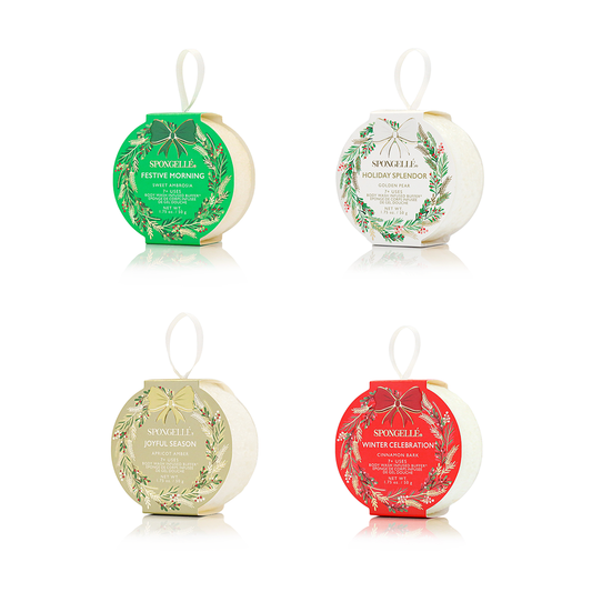 Four Spongelle holiday wreath body buffers with decorative labels on a white background